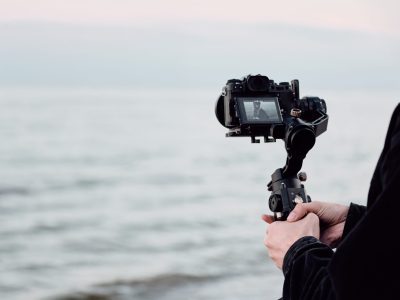 Pretty cute African American girl happily posing on camera during photo session by the sea